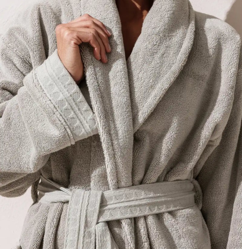 une personne portant un peignoir épais en coton gris