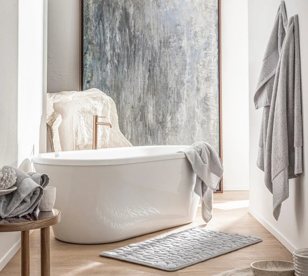 Salle de bain lumineuse avec baignoire design et accessoires moelleux